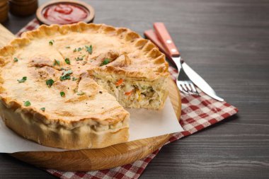 Lezzetli ev yapımı turta ve çatal bıçak takımı ahşap masada, yakın plan.