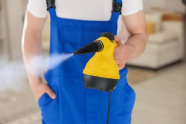 Evde buhar temizleyicisi olan kapıcı, yakın çekim.