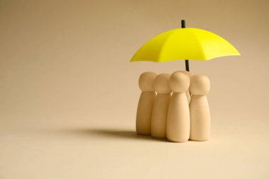 Bej arka planda şemsiye altında insan figürleri, mesaj için boşluk. Sigorta konsepti