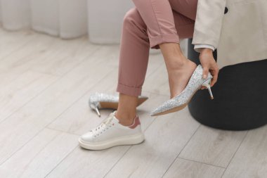 Evde ayakkabılarını değiştiren bir kadın, yakın çekim. Metin için boşluk