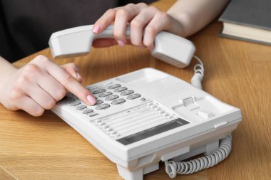 Ahşap masada telefonla arayan kadın, yakın plan.