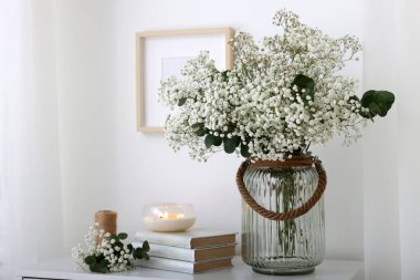 Güzel çigila çiçekleri ve okaliptüs dalları vazoda iç çekmecelerin üzerindeki dekoratif elementlerin yanında.