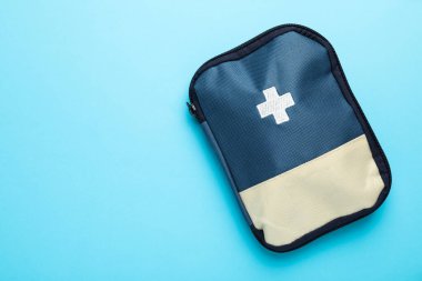Açık mavi arka planda ilk yardım çantası, üst manzara. Metin için boşluk