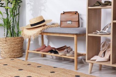 Farklı şık ayakkabılar, hasır şapkalar, poşetler ve ev bitkileriyle ayakta duruyor.