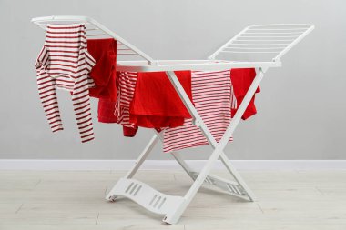 Gri duvarın yanında temiz çamaşırları olan kuru askı.