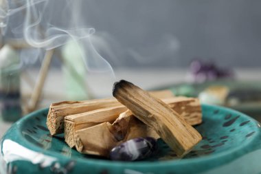Yanan palo santo sopası ve değerli taş masanın üstünde, yakın plan.