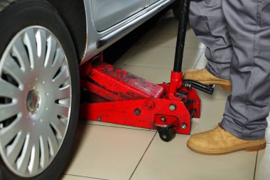 Benzin istasyonunda makas kriko ile otomobil kaldırma, yakın çekim