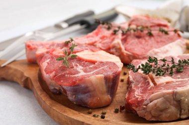 Açık gri masada çiğ et ve baharat parçaları, yakın plan.