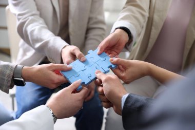 Birlik konsepti. İnsanlar yapboz parçalarını içeride birleştiriyor, yakın plan yapıyorlar.