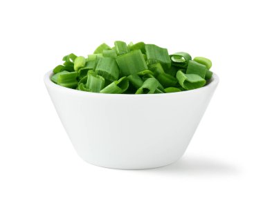 Taze doğranmış yeşil soğan beyaz kasede izole edilmiş.