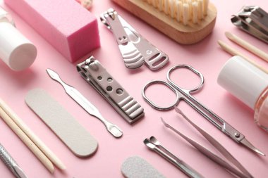 Pembe arka planda farklı manikür araçları seti, yakın plan