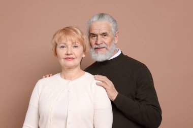 Bej arka planda sevimli yaşlı bir çiftin portresi