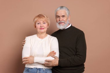 Bej arka planda sevimli yaşlı bir çiftin portresi