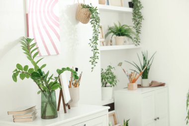 Evde farklı yeşil desenlere sahip raf ünitesi.