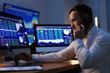 Finansal ticaret uzmanı geceleri telefonda konuşuyor.