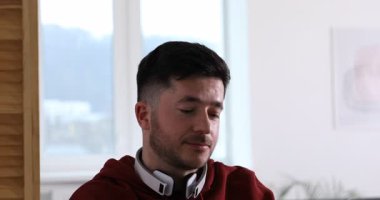 Kendi kendine çalışma. İçerideki masada ders sırasında not alan bir adam. Kamera aşağı iniyor