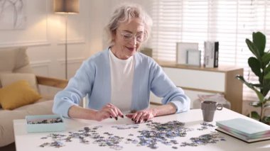 Beyaz masada yapboz çözen bir kadın.