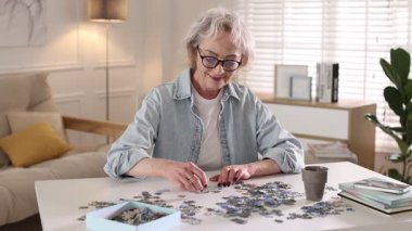 Beyaz masada yapboz çözen bir kadın.