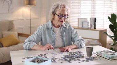 Beyaz masada yapboz çözen bir kadın.