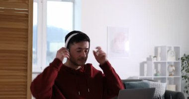 Kendi kendine çalışma. İçerideki masada dizüstü bilgisayar kullanarak öğrenen bir adam. Kamera aşağı iniyor