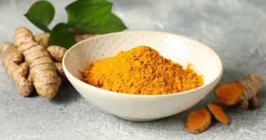 Gri masadaki kaseye tozu serpiyor. Yakın plan.