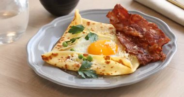 Yumurtalı, pastırmalı ve ahşap masada parmesan peynirli leziz krep, yakın plan. Kamera sola hareket ediyor