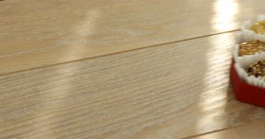 Ahşap masada çiçek şeklinde çikolatalı bonbonları olan kadın, yakın plan.