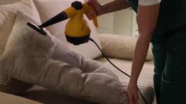 Profesyonel temizlikçi kanepe yastığı ile evde buhar temizleyicisi, yakın çekim