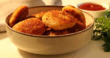 Lezzetli köfteyi alıp hafif desenli masada ketçapa batırıyorum. Yakın plan.