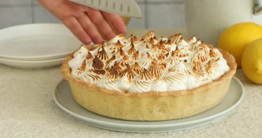 Açık dokulu masada lezzetli kremalı turta kesen kadın, yakın plan.