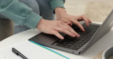 Beyaz masada dizüstü bilgisayarda yazan bir kadın, yakın plan. Kendi kendine çalışma.