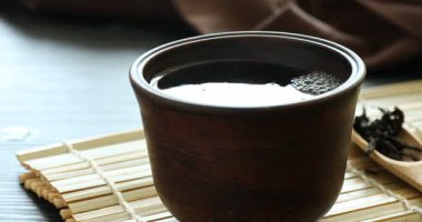 Ahşap masada fincanda romatik çay, yakın plan.