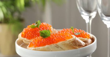 Kırmızı havyarlı lezzetli sandviçler bulanık arka planda, yakın planda.