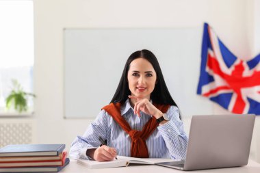 Sınıfta masa başında çalışan İngilizce öğretmeni