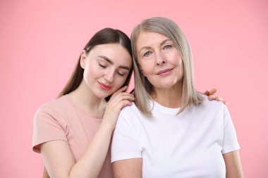Pembe arka planda sağlıklı ciltli güzel kadınların portresi