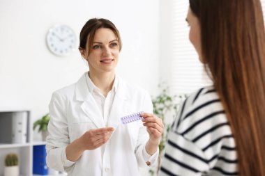 Jinekolog klinikteki kadınlara doğum kontrol hapı öneriyor.