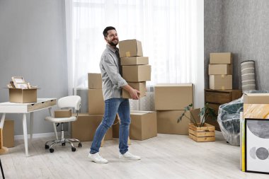 Taşınma günü. Yeni evinde karton kutuları olan bir adam.
