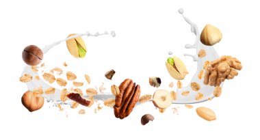 Yulaf gevreği, fındık ve beyaz arka planda havaya süt sıçratma. Pankart tasarımı