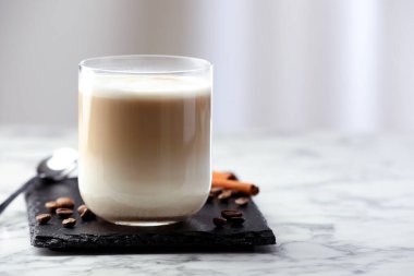 Tasty latte macchiato in glass on marble table, space for text. Coffee drink