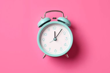 Pembe arka planda turkuaz alarm saati, üst görünüm