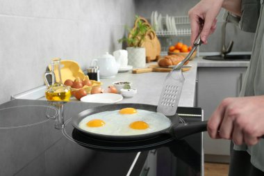 Kadın tavada yumurta pişiriyor. Kapalı mekanda, yakın plan.