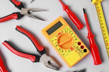 Different electrical tools on grey background, flat lay