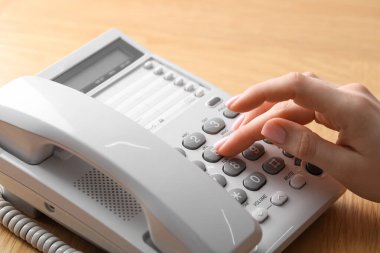 Ahşap masada telefonla arayan kadın, yakın plan.