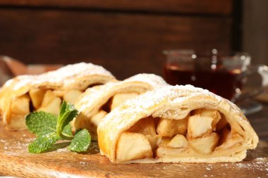 Lezzetli elmalı turta, pudra şekerli ve nane şekerli, ahşap tahtada, yakın plan.
