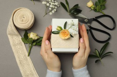Çiçek kutusu, çiçek, makas ve kurdeleli gri arka plan, üst manzara