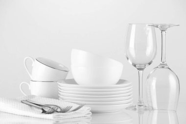 Açık arkaplanda farklı temiz bulaşık takımı ve çatal bıçak takımı