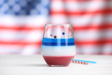 Lezzetli cam kokteyl ve beyaz tahta masa üzerinde pipet ABD bayrağına karşı.