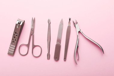 Pembe arka planda farklı manikür araçları, düz yatış