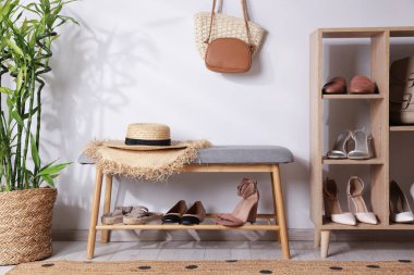 Farklı şık ayakkabılar, hasır şapkalar, çantalar ve ev bitkileriyle duruyor.