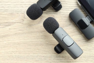 Lavalier mikrofonlar ve ahşap masada kablosuz alıcısı olan akıllı telefon. Metin için boşluk